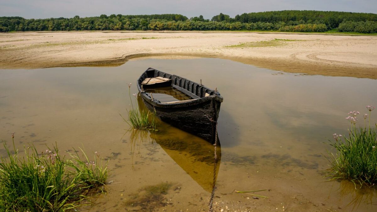 A boat banked on a sand in an area that is usually submerged in the Danube River in Rasova, Romania.