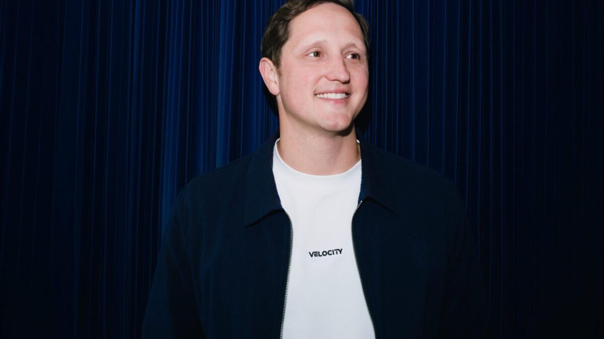 Velocity CEO Eric Queathem smiles as he looks to the far left.