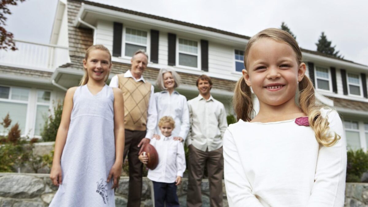 Several members of a family standing together in front of a house