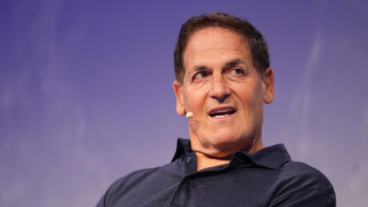 Mark Cuban, in front of a purple background, has his mouth open and is looking to his left.