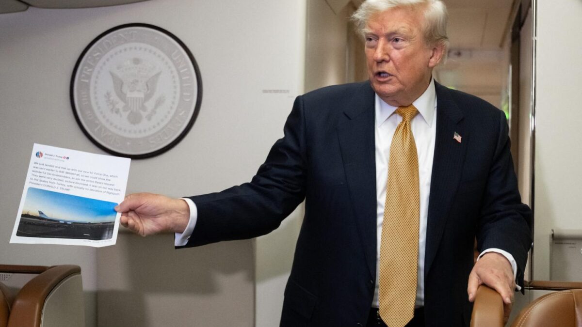 President Donald Trump holding up a printed out Truth Social post