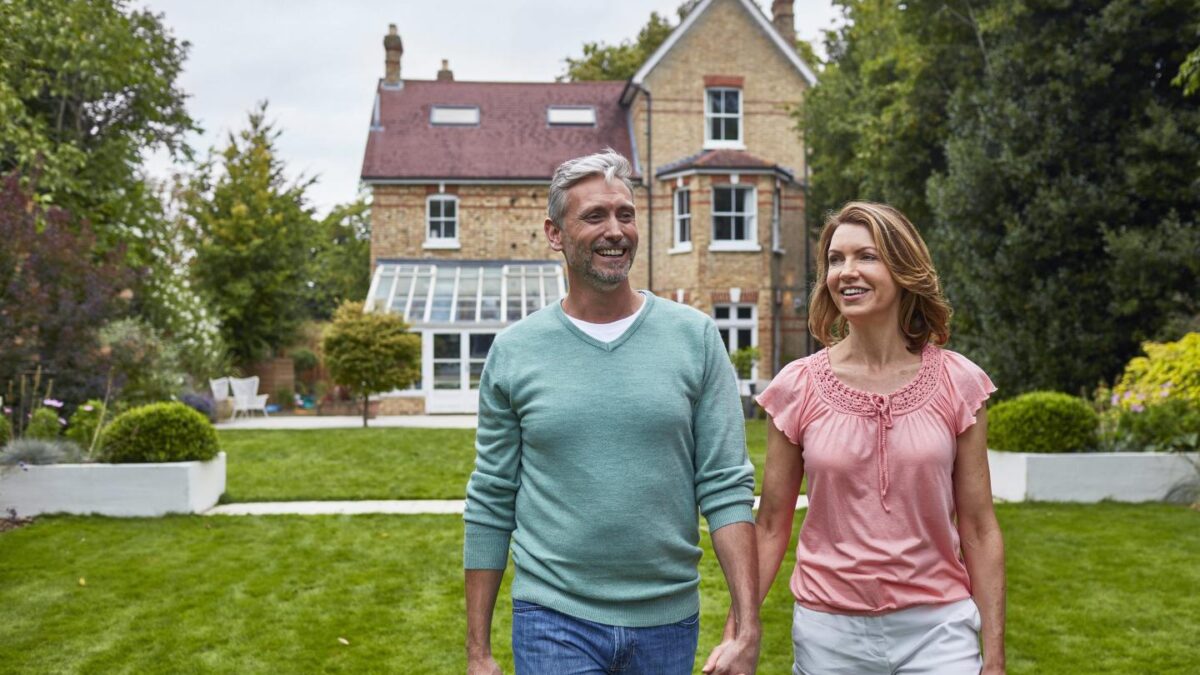 American couple walking in front of London mansion